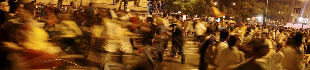 Photograph representing politics, ethics and applied philosophy shows a crowd rioting in night city scene.