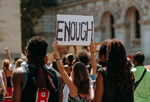 Protest march with word Enough on a prominent banner. Photograph by Liam Edwards. CC Unsploash.