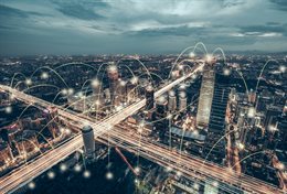 An aerial view of the dense Beijing cityscape with arcing lines added to show connectivity. Symbolising innovation and urban ecosystems.