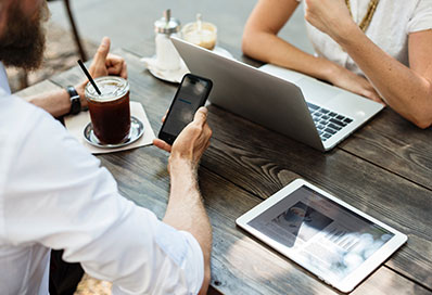 Bearded man with a coffee looking at his mobile phone