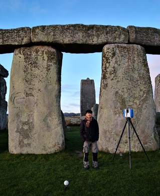 Stonehenge with scientist and PhD student Gavin Leong using observational equipment on the key stones to gain data on Earth's lithosphere.