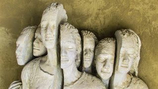 Sculpture created from figures divided vertically in half and arranged together representing the plight of refugees
