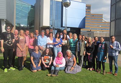 A group of people gathered for a photograph outside university buildings - the Centre of Resilience and Social Justice Team