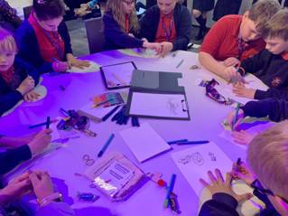 Children round a table drawing at the Resilience Revolution conference