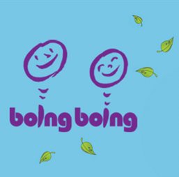 The words 'boing boing' painted in purple with happy faces for the dots on the 'i' and leaves falling around it against a pale blue backdrop.