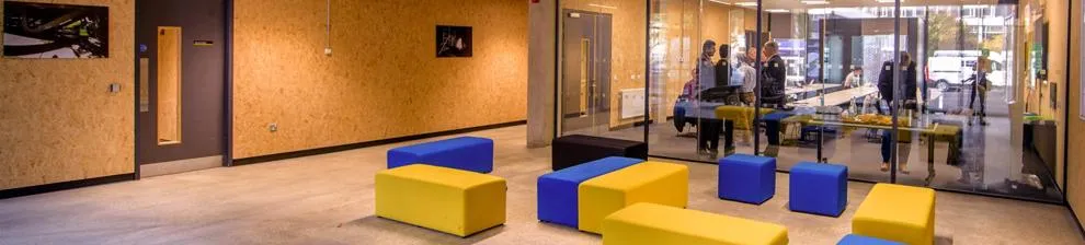 Interior of University of Brighton Advanced Engineering Building with people chatting in a glass room