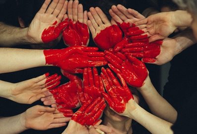 Children's hands with a heart painted across them all.