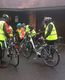 Cyclists standing by their e-bikes