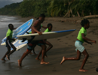 Young people walking with sufboards as part of the Choco surf project