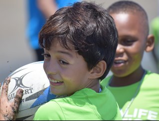 Two children play with a rugby ball as part of the University of Brighton's work through Rugby 4 Peace in Choco, Colombia