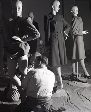 Curators work to dress mannequins for exhibition display. Britain Can Make It Exhibition, 1946.