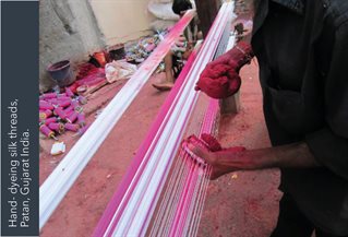 Hand dyeing thread pink on a loom with hand pigments