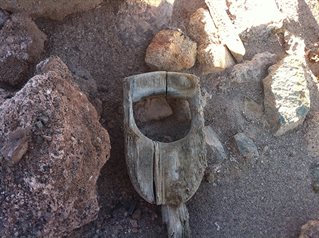 Wooden handle of a shovel among rocks. Louise Purbrick, Traces of Nitrate