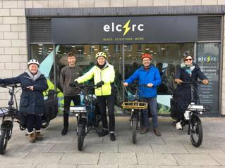 Staff of University of Brighton and Elctrc cycles in front of Elctrc shop four with electric e-bikes.
