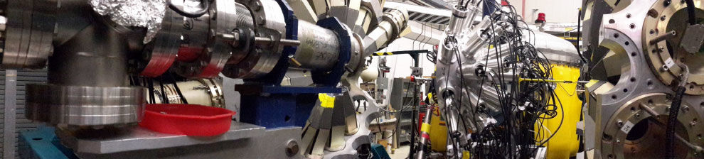 Laboratory for Nuclear Physics research showing heavy machinery, featuring chrome cylinders and large-scale tubing.