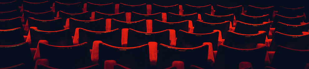 Illustrating media and communications research study, photograph of rows of red plush chairs like those used in traditional cinemas