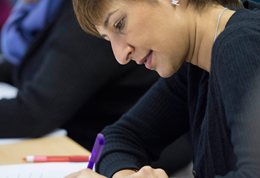 Postgraduate student at a desk writing a funding application