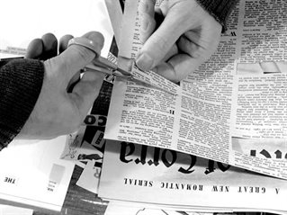 Black and white image of Graham Rawle cutting a strip of words from a magazine.