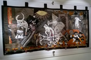 Tapestry with innovations on the elements of Picasso's Guernica picture including bull's head and large eye shape. Also images of the plight of African people. Keiskamma Guernica 2015.