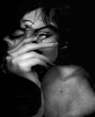 Still image from experimental dance film work by Billy Cowie. Dancer Gabriela Alcofra's side on head in black and white is blended and distorted with a superimposed projected hand.