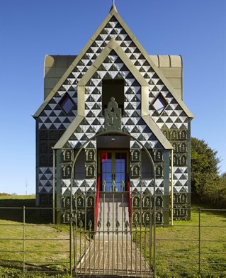 Front face of stylised building with pointed outline and tile decorations. Charles Holland and Grayson Perry's House for Essex.