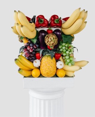 The shape of Corinthian column capital made from a variety of fruits. Charles Holland Origins exhibition at the Royal Academy, London. Called origins of the Grocer's Order.