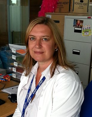 Dr Melanie Flint is a Reader in Cancer Research and is the leader of a stress and Portrait of Melanie Flint in cancer research offices with white lab coat. Her work considers whether stress causes cancer.