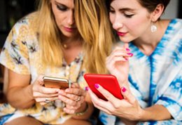 Two women looking at their phones.