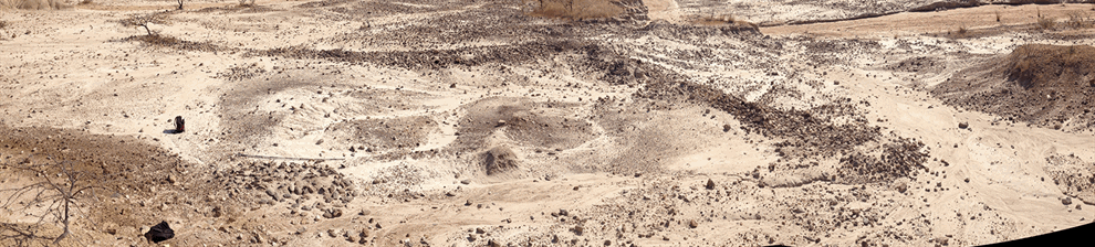 Image representing research in archeology showing an arid landscape from high aerial viewpoint and excavation features.