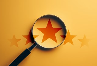 Star shown through magnifying glass on orange background