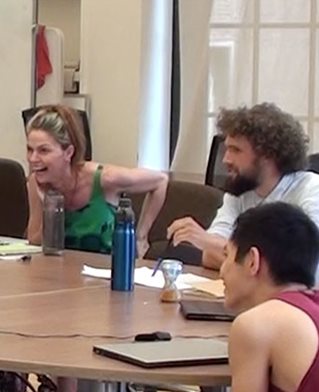 Three participants in a poetry project reacting to works from around a table