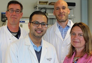 Photograph of four scientist, three men and one woman, all in lab coats with laboratory background. Members of the research Centre for Stress and Age-related Diseases
