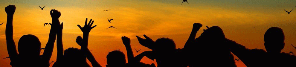 People with hands in the air at a party on the beach at dusk