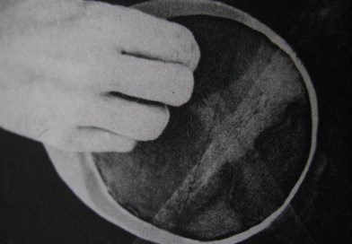 Black & white image of a hand holding a vessel