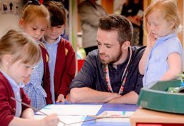 Teacher with young pupils illustrating the Pedagogy, Professional Learning and Organisational Change Research and Enterprise Group