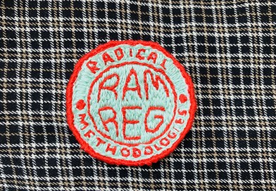 "Radical Methodology" embroidery patch on tartan material. Image credit: Sally Sutherland 2020