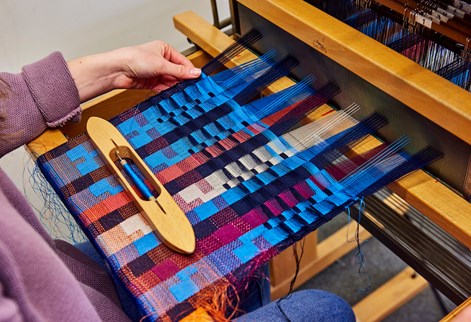 Close-up of a student using a loom