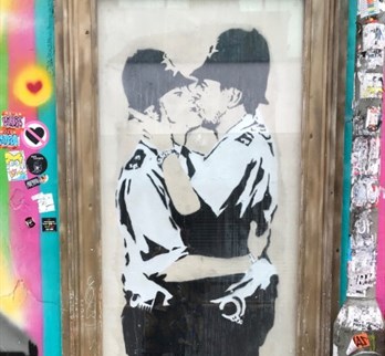Street art of two policemen kissing by Banksy