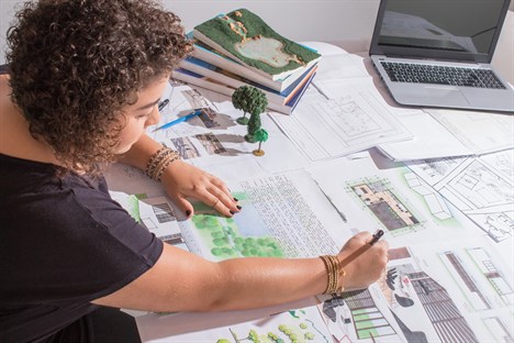 female drawing a urban city design plan