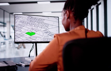 female working with city building cadastre map on computer screen