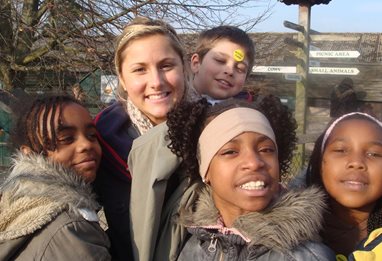 An adult with a group of young people in the countryside