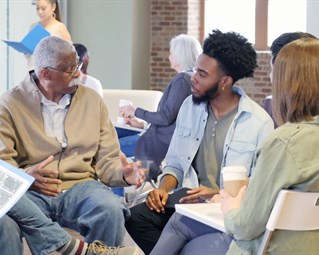 Young and old people chatting around a table