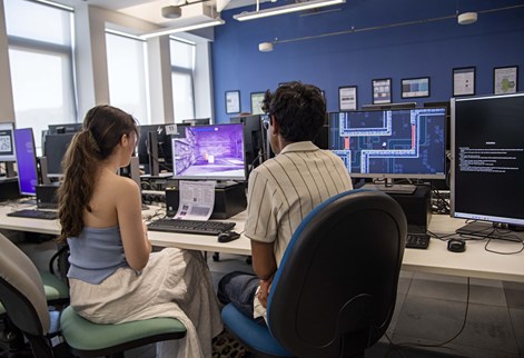 Two students looking at a monitor in a computer lab