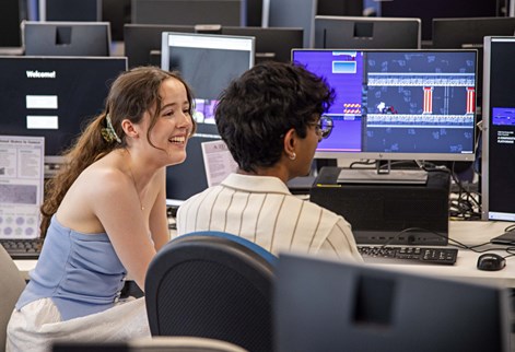 Two students sitting at computers in a lab