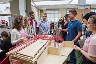 Group of students discussing model of a structure