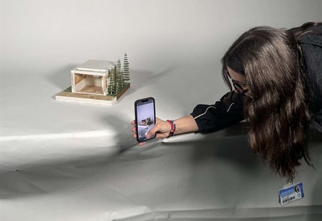 Architecture student photographing a model in a studio setup
