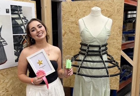 Product Design student Tilly beside a project created from discarded festival tent materials