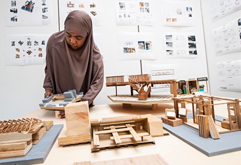 Architecture student arranging scale models for the summer show