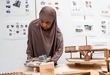 Architecture student arranging scale models