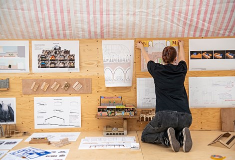 Architecture student arranging drawings and models for exhibition